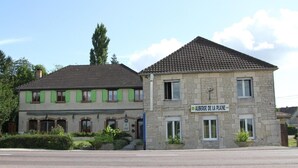 A two-story building with a stone facade and a tiled roof. The building has a sign that reads "AUBERGE DE LA PLAINE." - Auberge De La Plaine (La Rothiere)