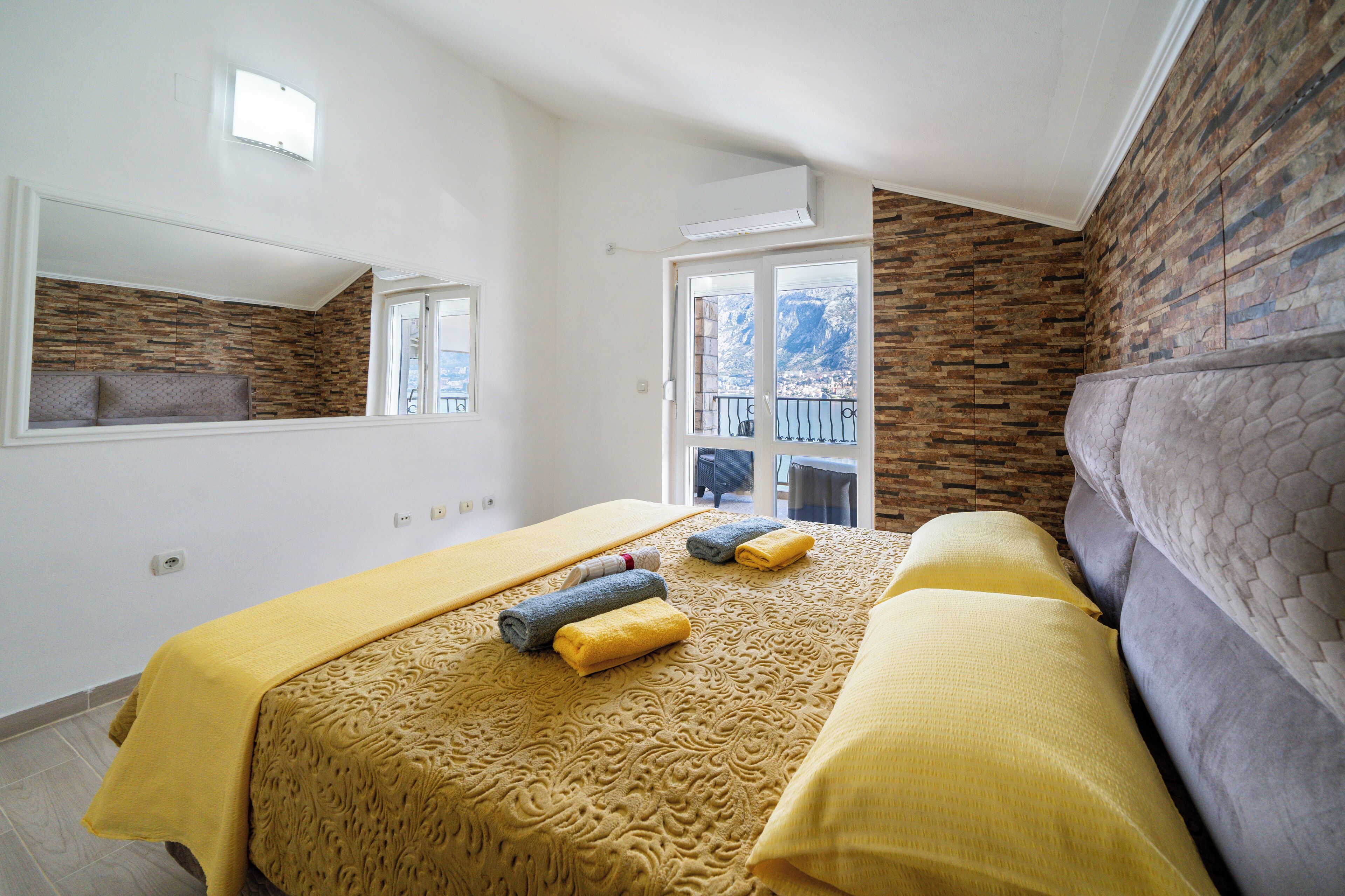 Une chambre à coucher avec un lit, un canapé, une fenêtre et une vue sur les montagnes.