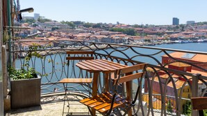 Uma varanda com vista para um horizonte urbano e um corpo d'água.