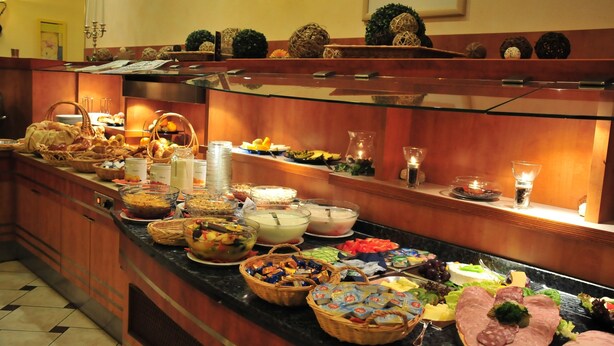 Un buffet proposant une variété de plats, notamment des fruits, des légumes et des viandes.