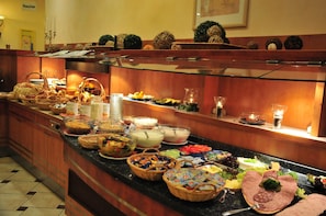 A buffet with various food items, including fruits, vegetables, and meats.