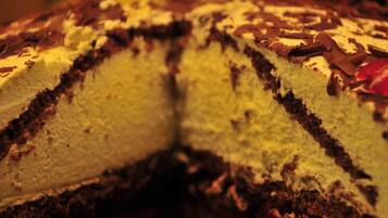 Una torta a più strati con scaglie di cioccolato in superficie.