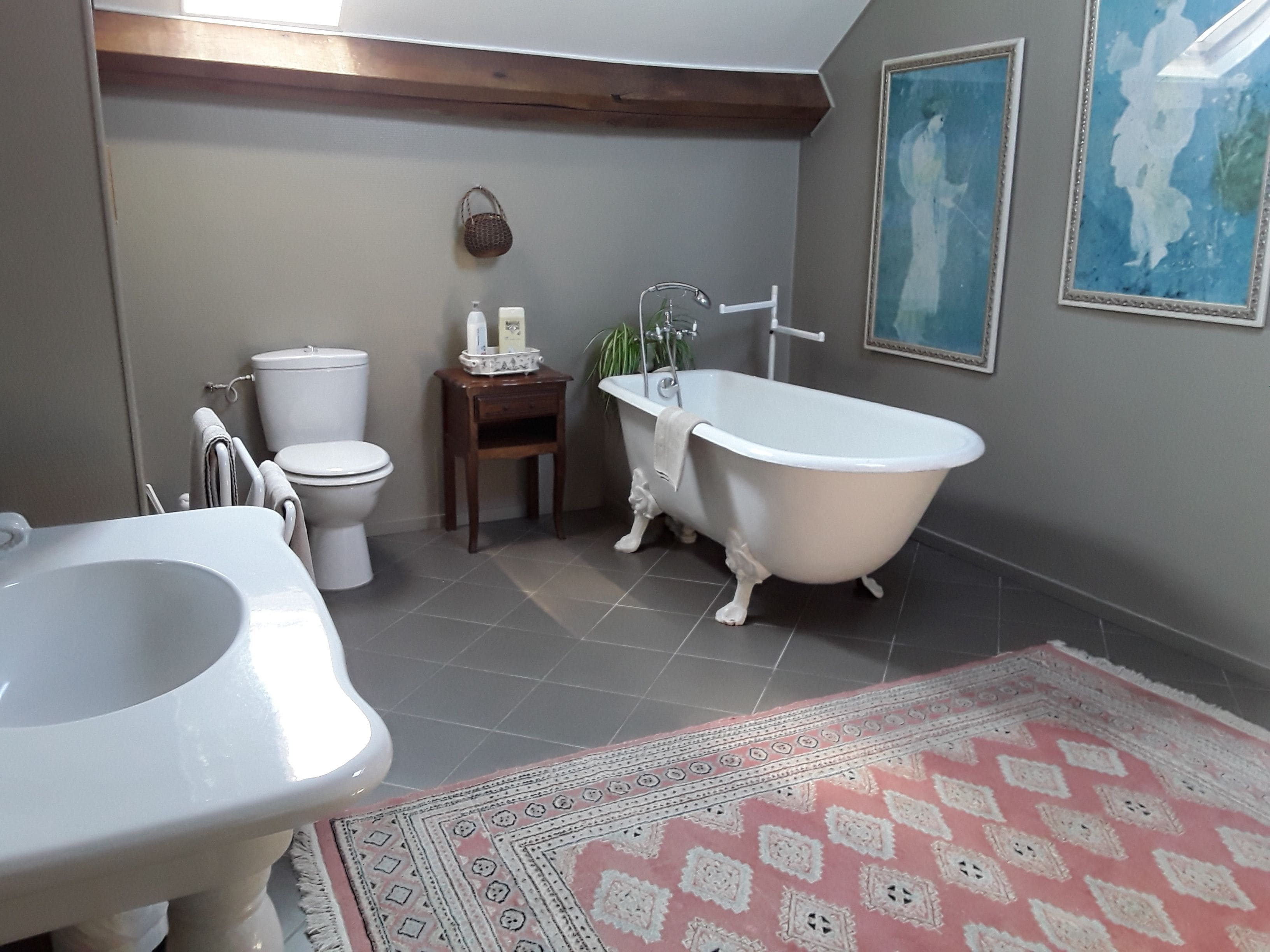A bathroom with a clawfoot bathtub, a toilet, and a sink.
