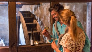 A wooden interior with a rustic staircase and a bottle of wine on a table. - Hotel Landgasthof Zum Weissen Schwanen (Braubach)