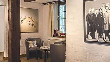 Una habitación con chimenea, una estantería y una fotografía enmarcada en la pared.
