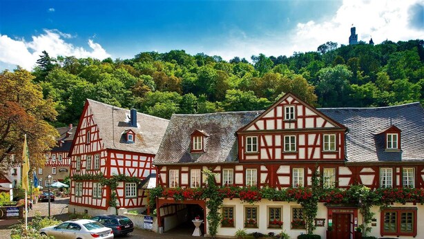 A traditional half-timbered building with a steeply pitched roof, a visible chimney, and a small window. - Hotel Landgasthof Zum Weissen Schwanen (Braubach)