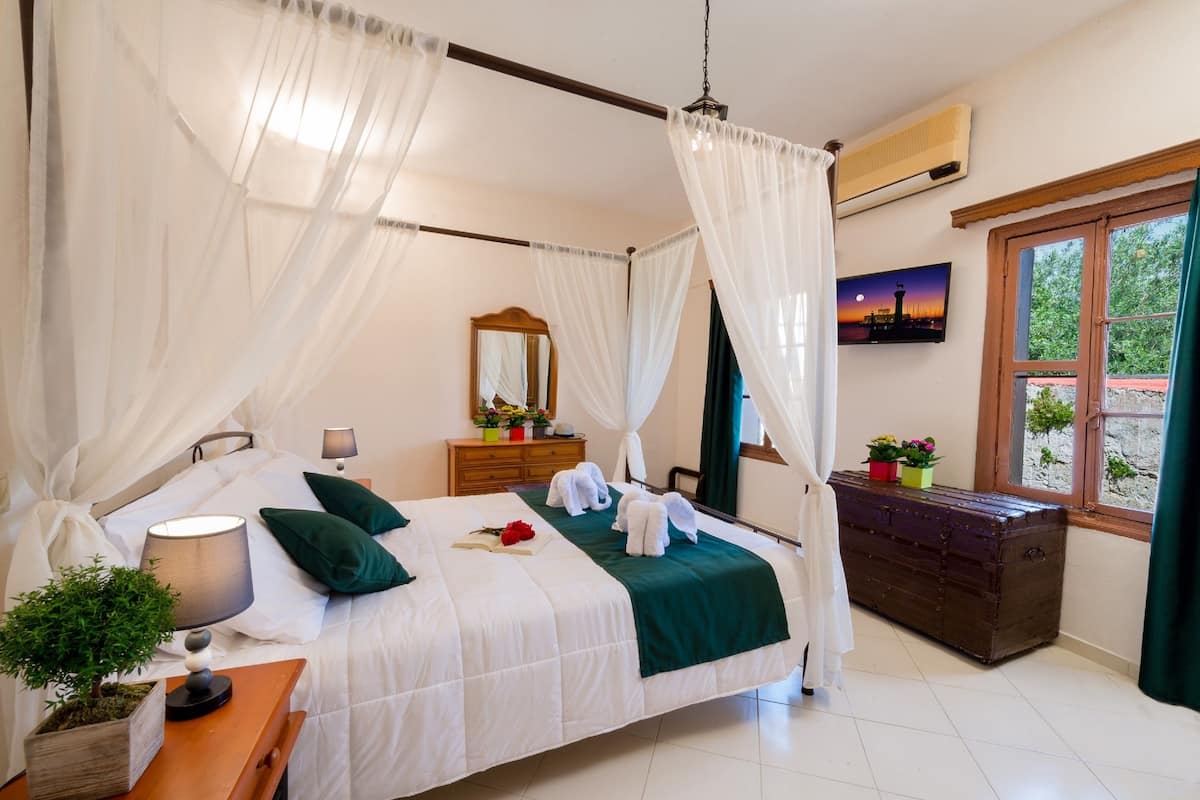 A neatly arranged bedroom with a bed, bedside table, and a dresser.