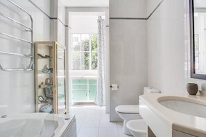 Bañera con ducha, secador de pelo, bidet, toallas