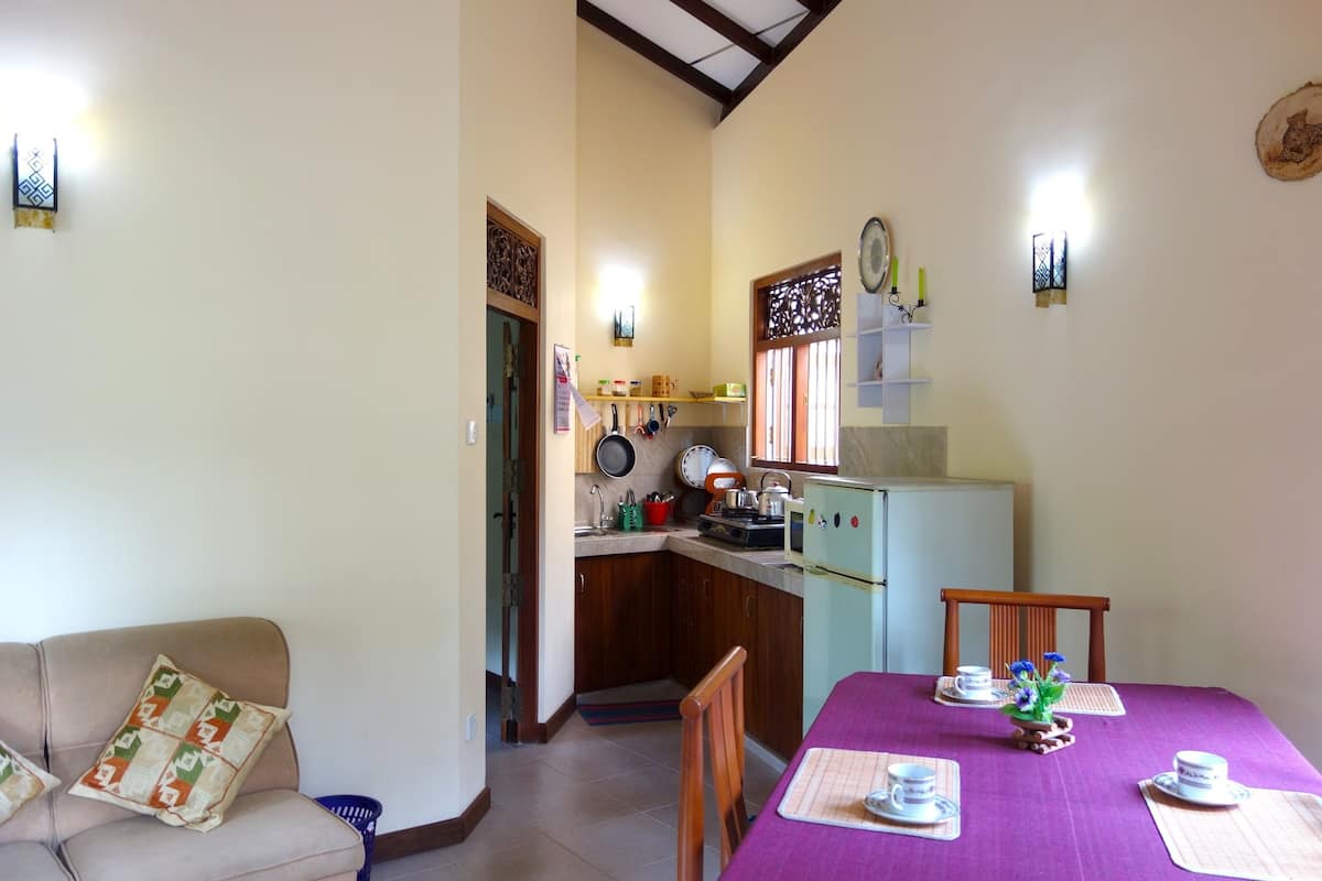 A compact living space with a kitchenette, a dining area, and a sofa.