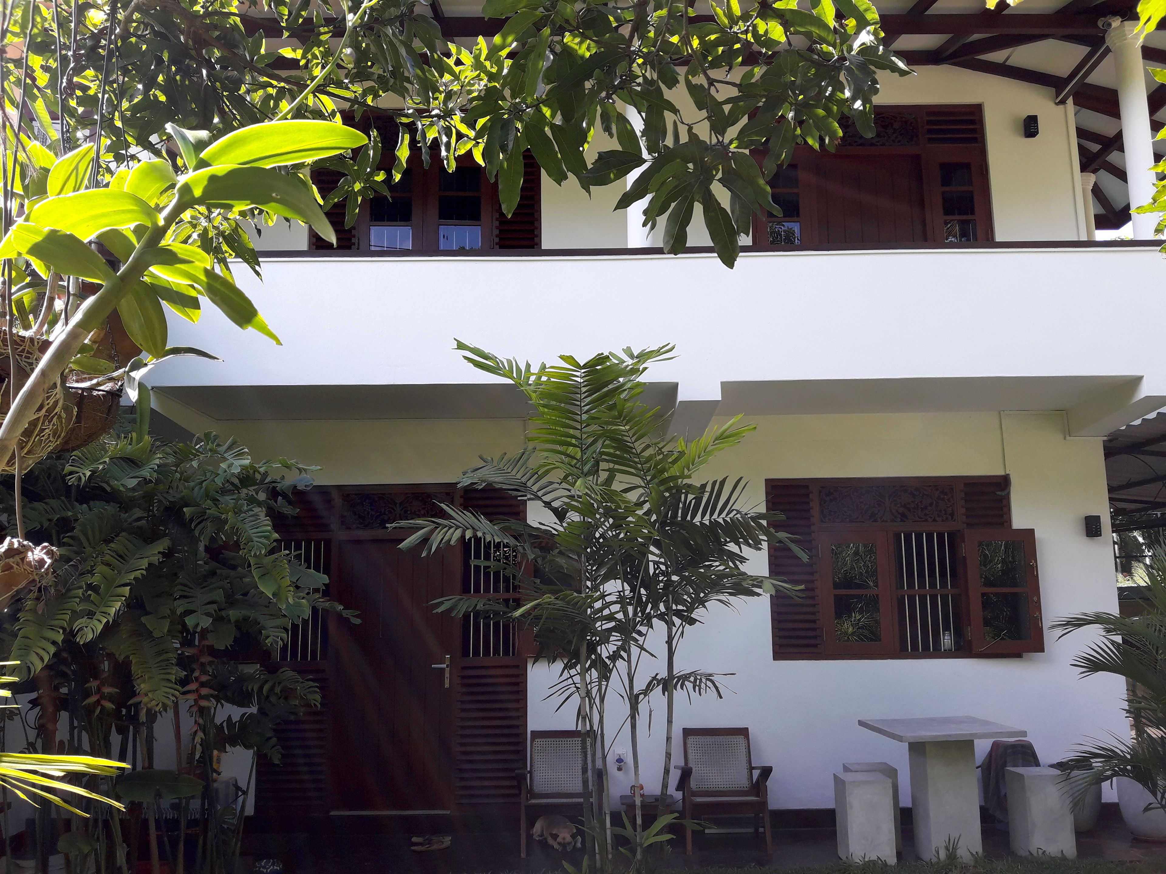 Il s’agit d’un bâtiment à deux étages doté d’un patio couvert. On y trouve plusieurs plantes en pot et un banc.