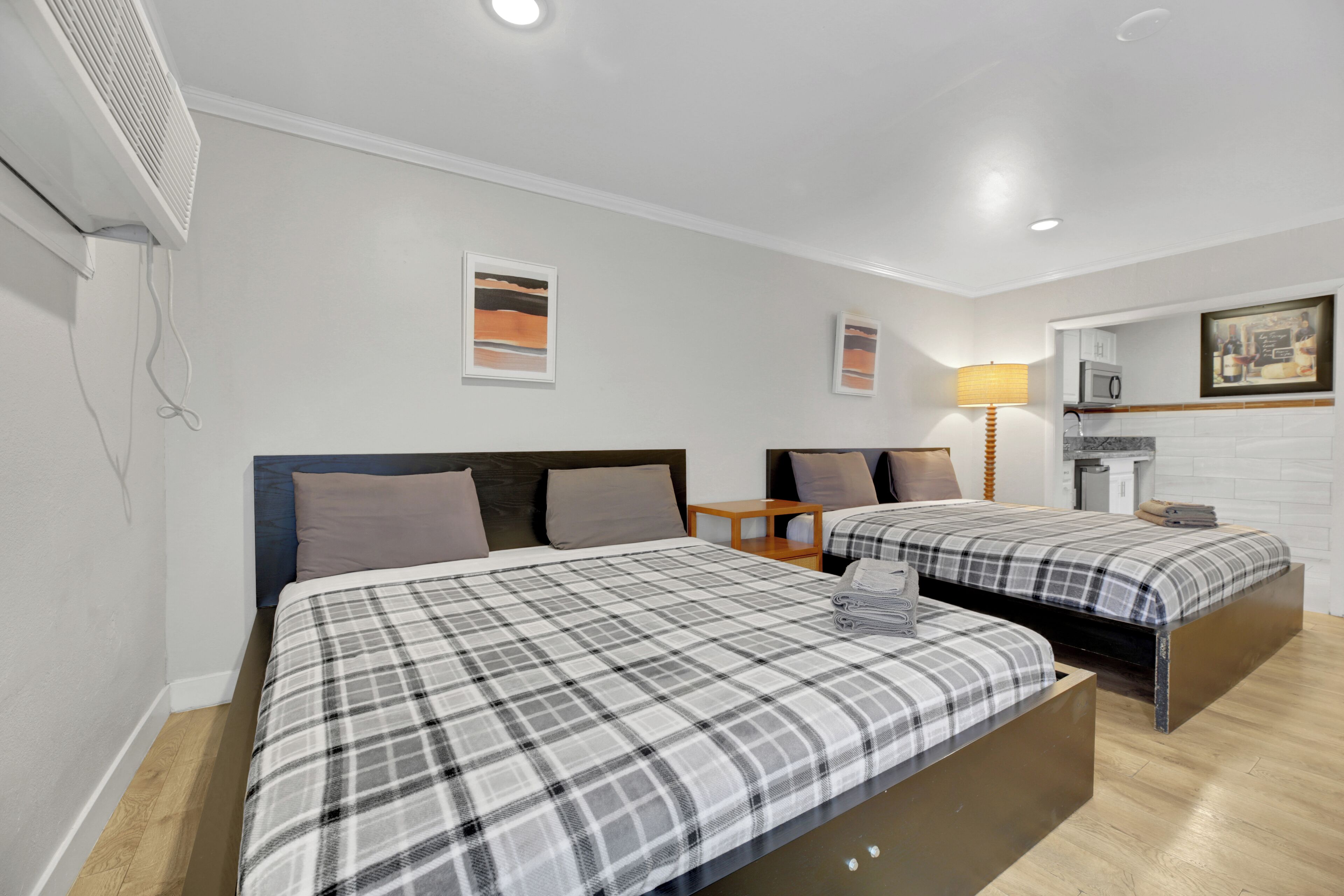 Une chambre d’hôtel avec deux lits, une kitchenette et un petit coin salon.