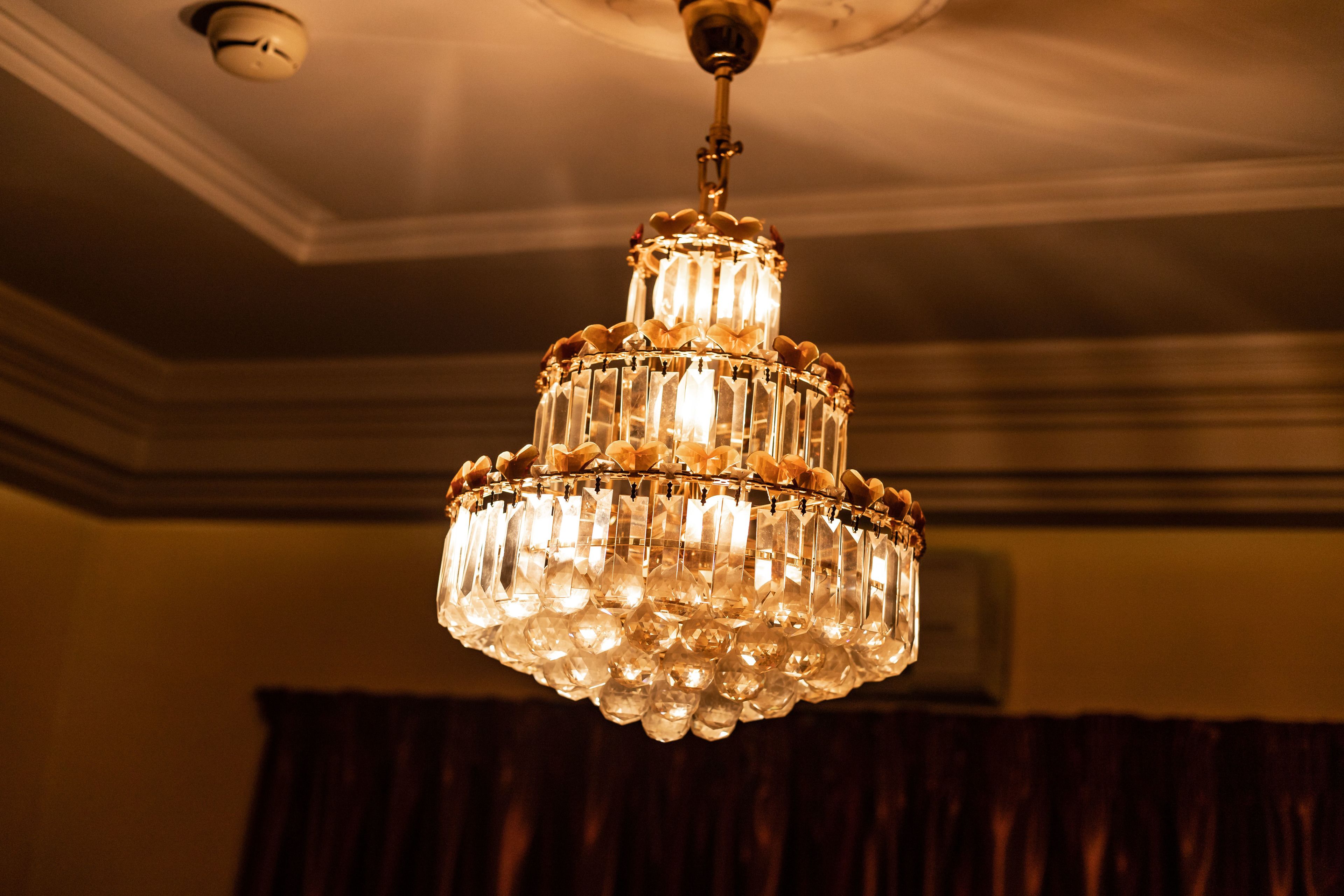 A chandelier with multiple tiers of clear crystal and lights.