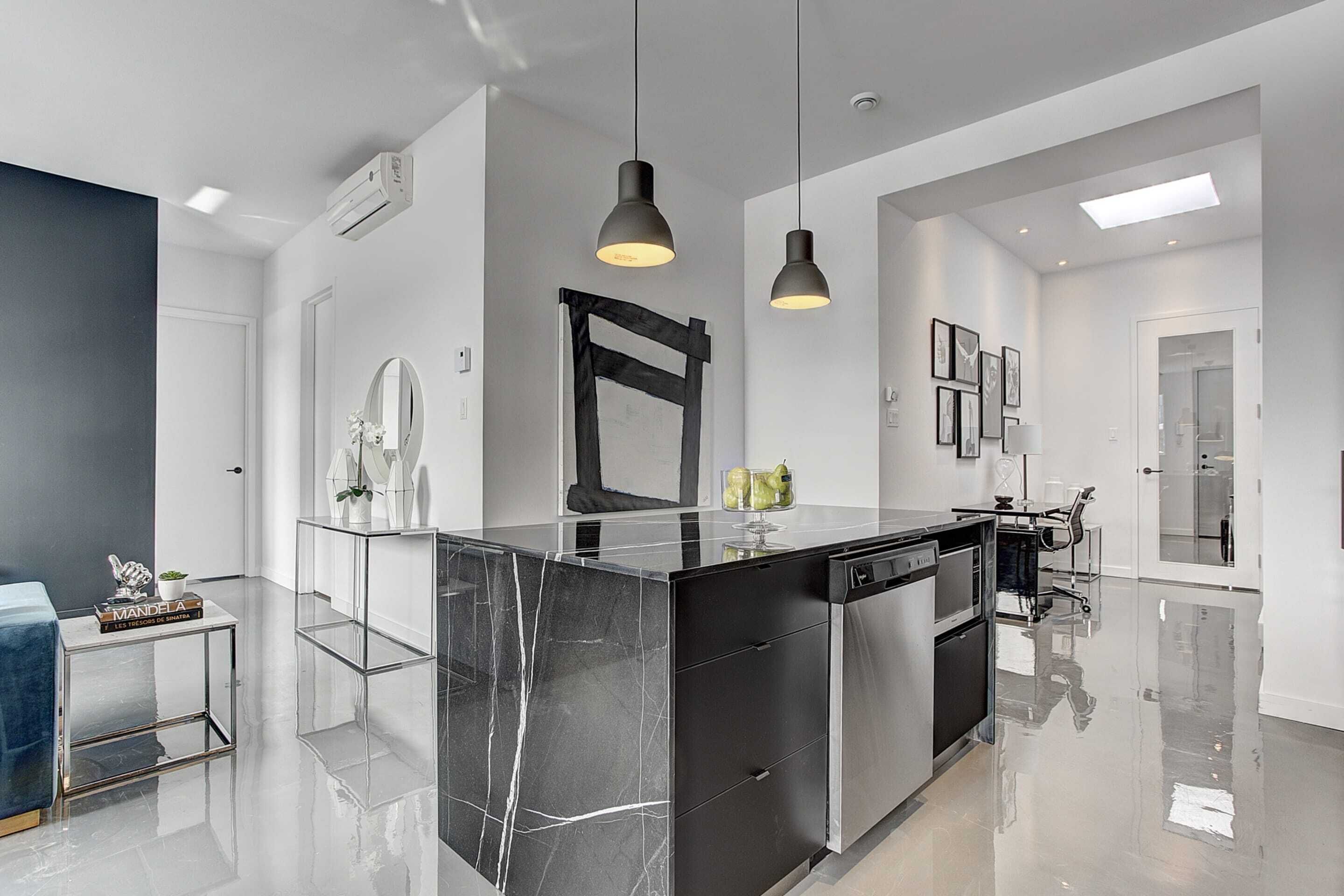A modern kitchen with a central island, pendant lighting, and a sleek design.