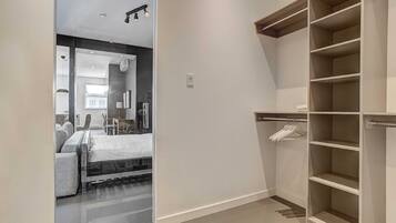 A modern bedroom with a bed, bedside table, and a walk-in closet with shelves.