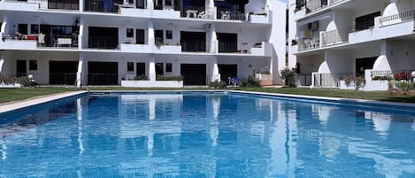 A modern building with a swimming pool in front.