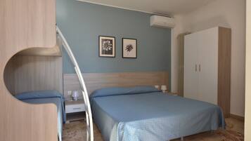 Un dormitorio con una cama, un armario y dos cuadros en la pared.