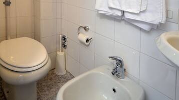 Ein Badezimmer mit Toilette, Bidet und Waschbecken.
