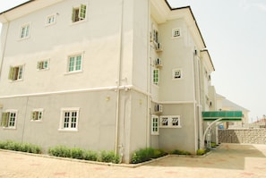 A multi-story building with a flat facade, multiple windows, and a green awning.
