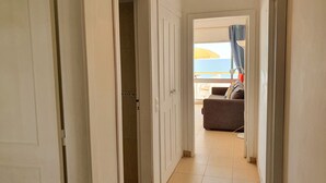 Un couloir menant à un balcon d’où l’on a vue sur la mer.