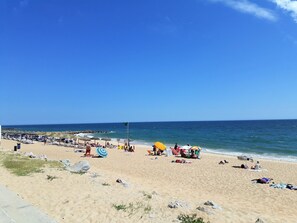 A beach with sun loungers, umbrellas, and people relaxing. - Praiamar 3f- Sea Front, Cozy, Private Parking (Quarteira)