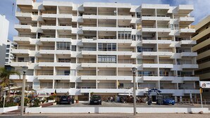 Un hôtel à plusieurs étages, doté de balcons, d’un parking et d’une enseigne indiquant le restaurant « The Hut ».