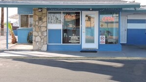 A motel with a blue exterior, a 'Gatewood' sign, and a 'OPEN' sign. - Walden Motel (Las Vegas)