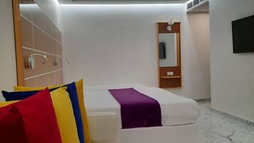 Una habitación de hotel moderna con una cama, un sofá, un televisor y un baño.