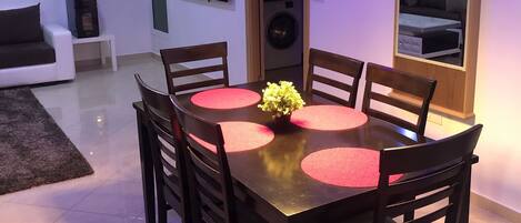 A modern dining area with a round table, chairs, and a central floral arrangement.