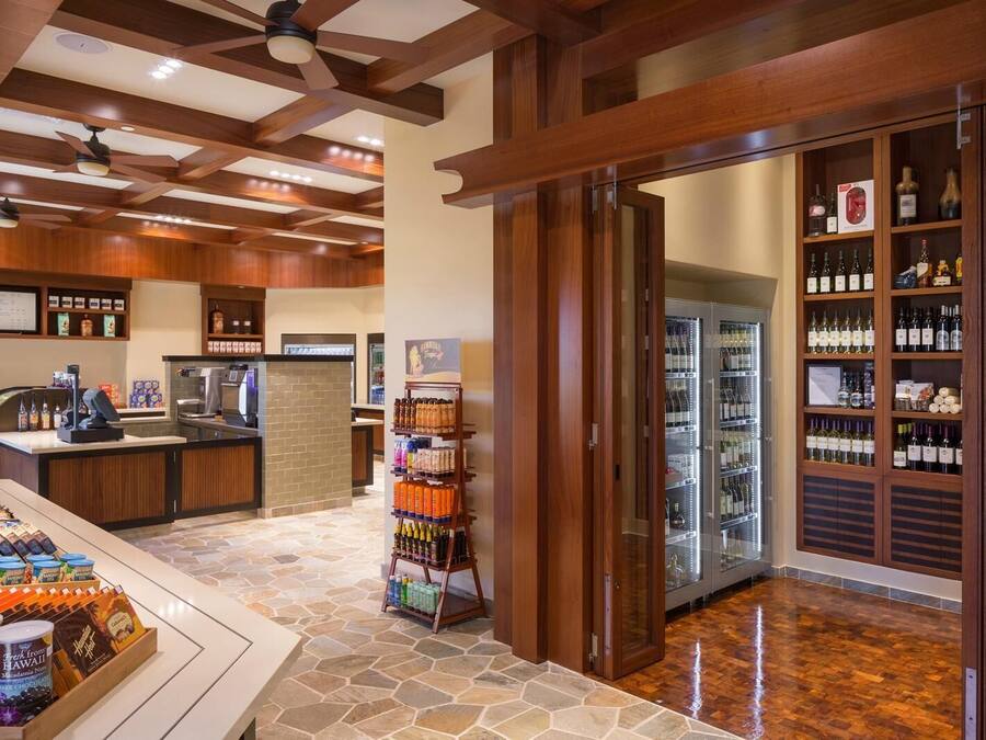 Vestíbulo de hotel con zona de bar, exhibición de bebidas y enfriador de vinos.