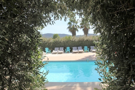 Una piscina al aire libre de temporada, sillones reclinables de piscina