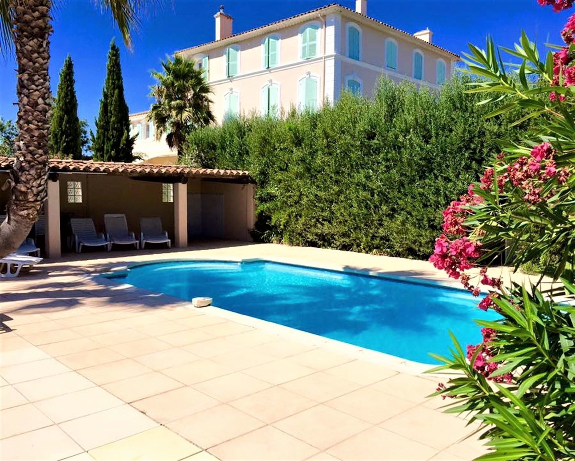 Een seizoensgebonden buitenzwembad en ligstoelen