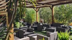 Un patio al aire libre con muebles de mimbre y plantas en macetas.