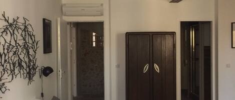 Un dormitorio con una cama grande, un armario y una puerta que da a otra habitación.