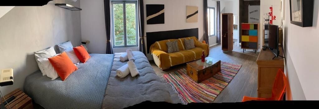 Un dormitorio moderno con una cama grande, un sofá y una televisión.