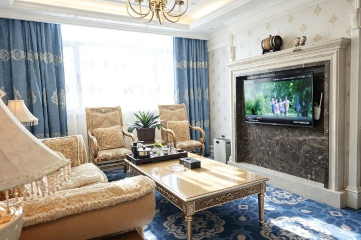 Una sala de estar con televisión, asientos cómodos y chimenea.