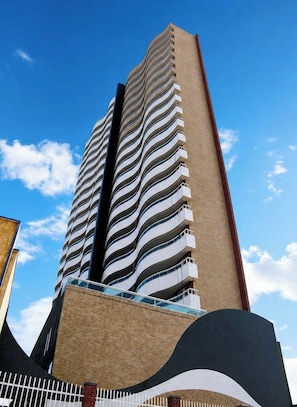 A high-rise building with a distinctive wavy facade and balconies. - Apartamento Vista mar Praia de Iracema (Fortaleza)