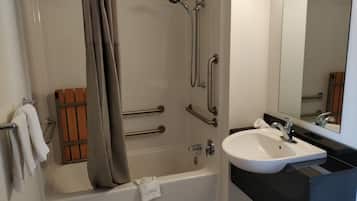A bathroom with a bathtub, shower, and sink.
