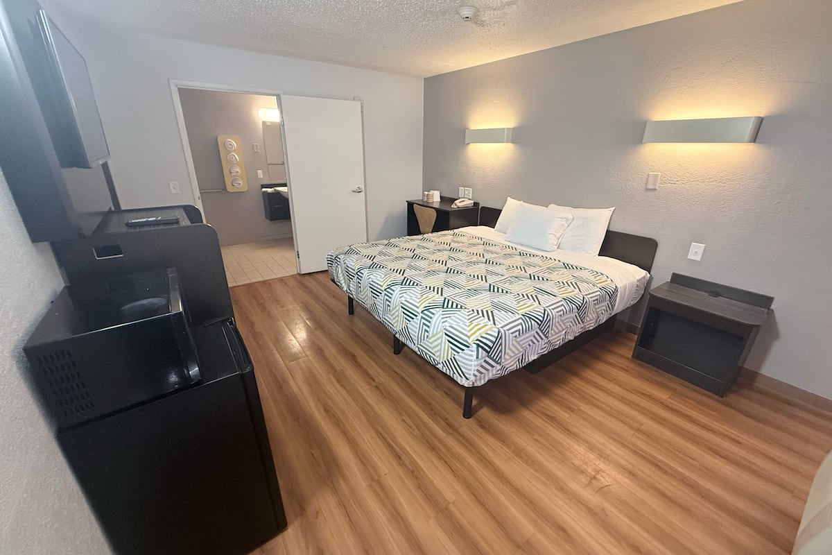 Ein Schlafzimmer mit einem Bett, Nachttischen, einem Schreibtisch und einem Kleiderschrank.