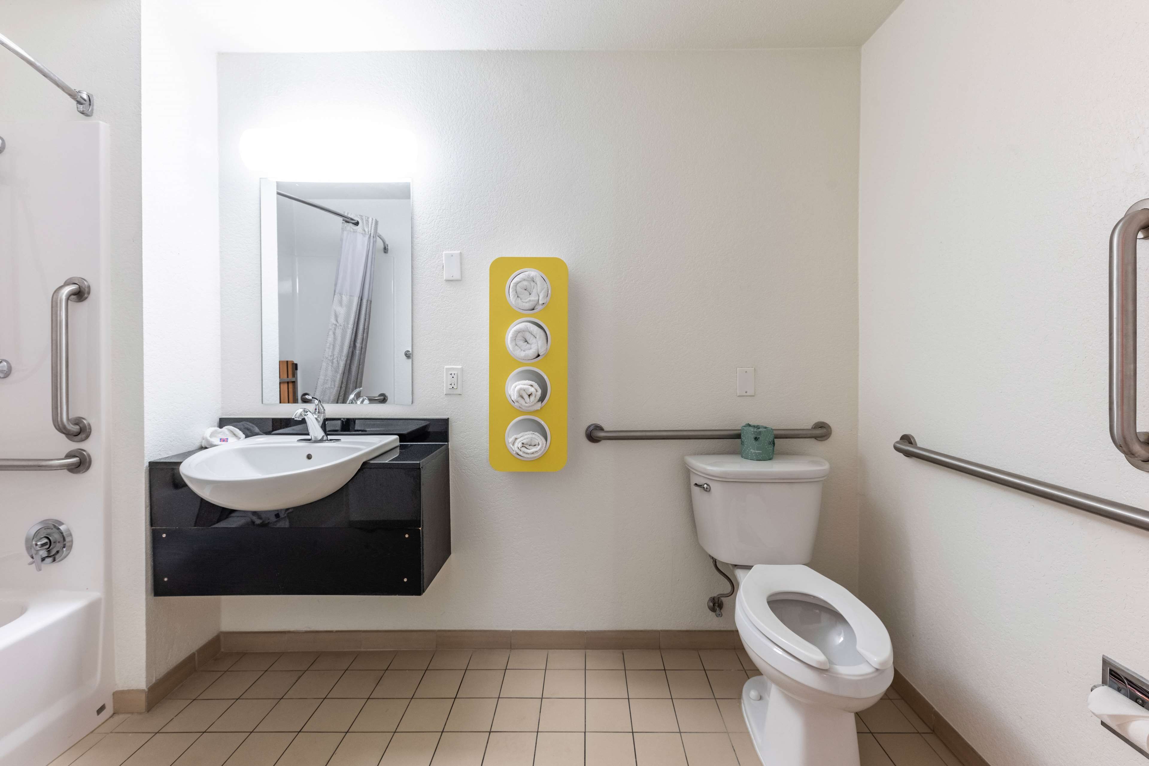 A bathroom with a white sink, a toilet, a bathtub, and a yellow towel rack.