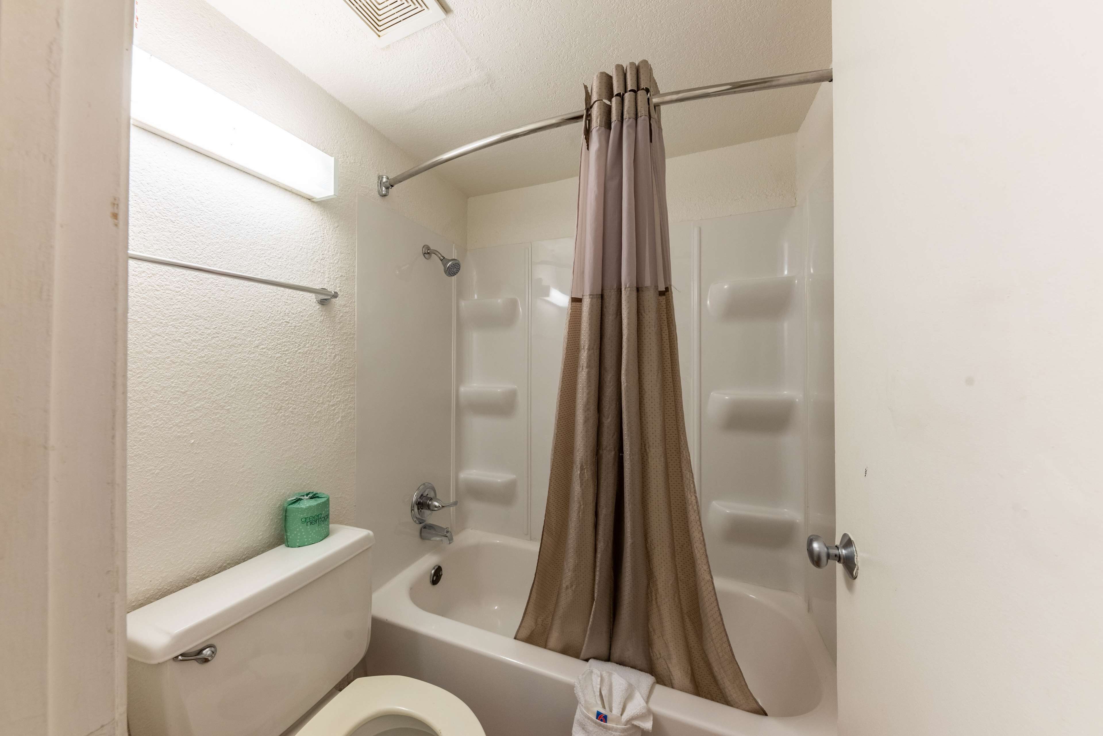 Un bagno con una vasca, il water e una tenda per la doccia.