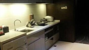A compact kitchen with a washing machine, a sink, and cabinets.