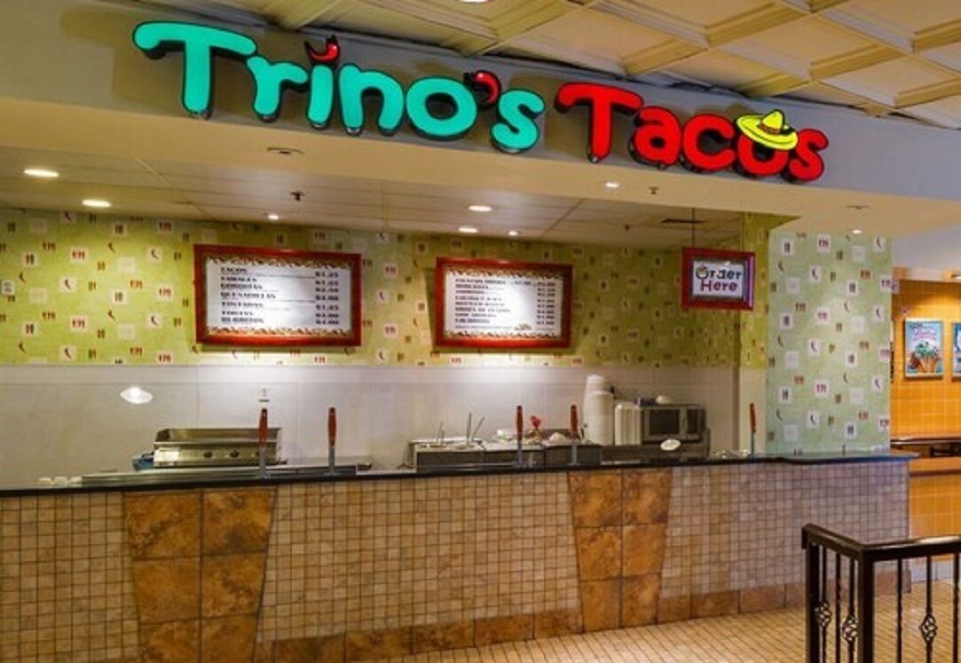 Trino's Tacos restaurant with a neon sign, menu boards, and a counter area.