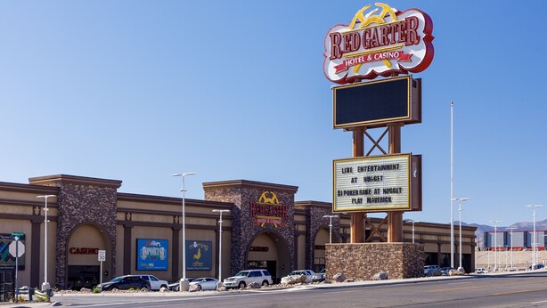 Un hôtel-casino Redgaster, avec une enseigne bien visible, un parking et un ciel dégagé.