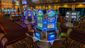 A casino floor with multiple slot machines and bar stools. - Red Garter Hotel & Casino by Red Lion Hotels (West Wendover)