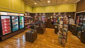 A general store with shelves stocked with various items, a refrigerated display case, and a clothing rack. - Red Garter Hotel & Casino by Red Lion Hotels (West Wendover)