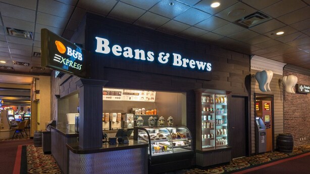 A Beans & Brews coffee shop with a counter, display cases, and a menu board. - Red Garter Hotel & Casino by Red Lion Hotels (West Wendover)