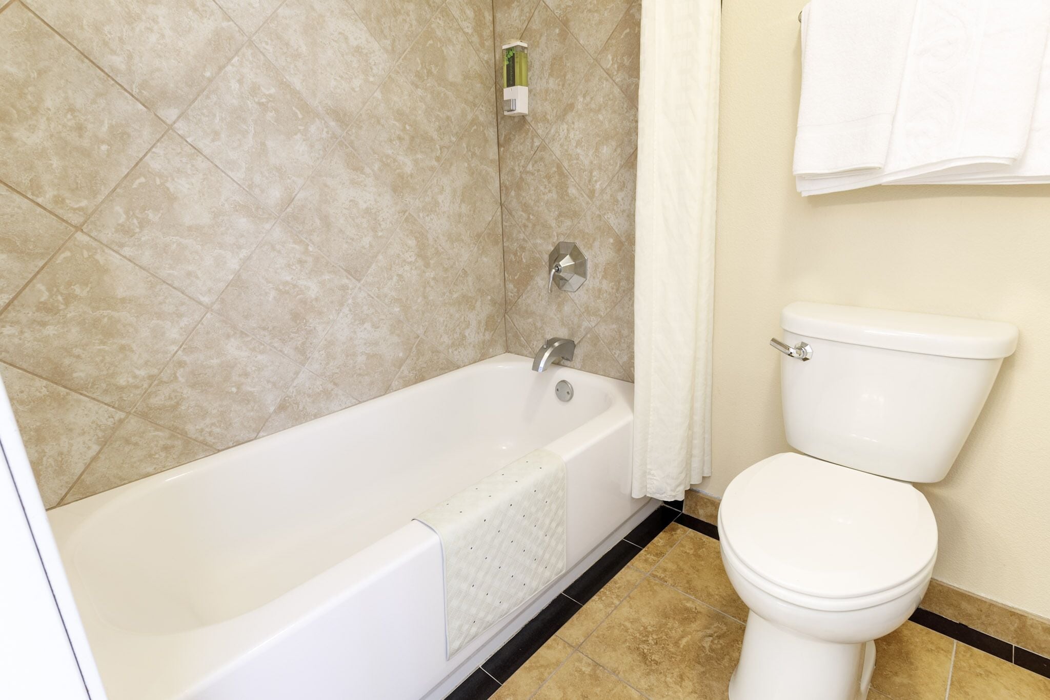 Ein Badezimmer mit Badewanne, Toilette und Handtuchhalter.