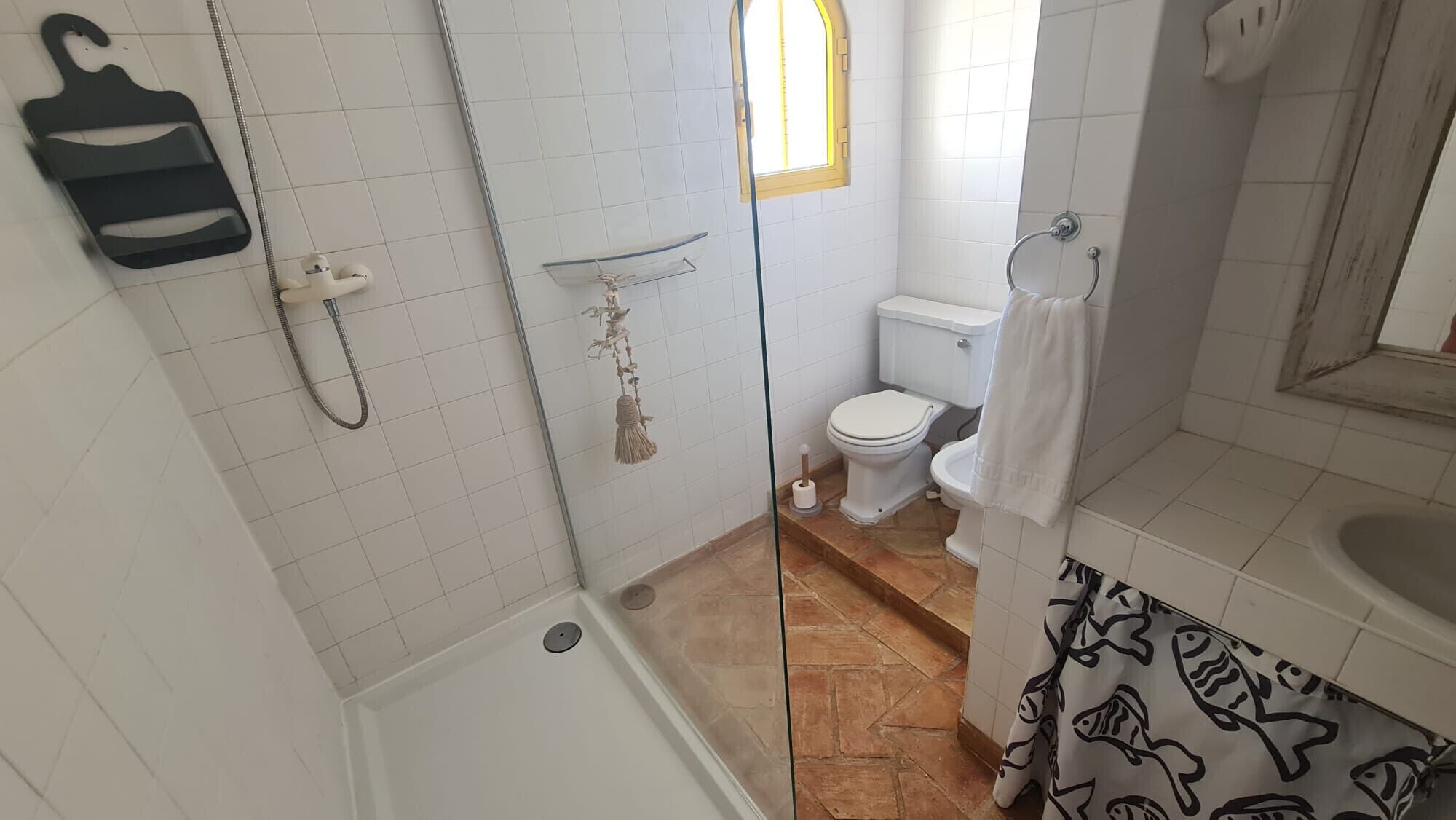 A bathroom with a shower, toilet, and bathtub.
