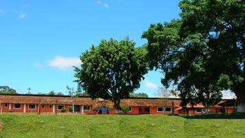 Un hilera de edificios con techos rojos y un campo verde frente a ellos.