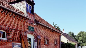 A brick building with a sign reading "Table." - Auberge de villechaume (Sennely)